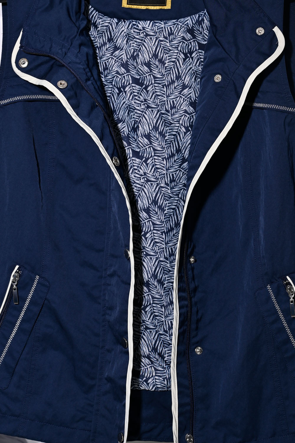 Navy blue sleeveless jacket with zipper and stylish patterned lining, featuring functional zippers and buttons.