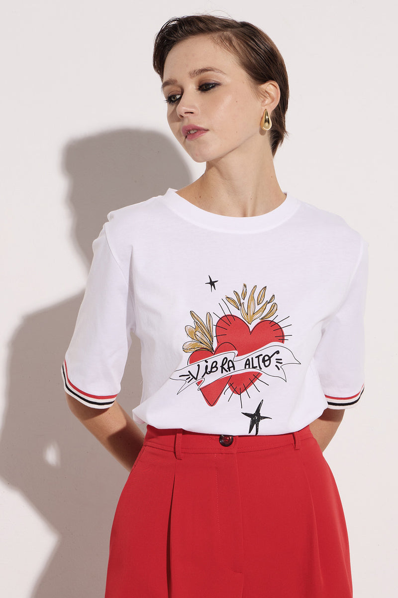 White T-shirt with heart print and striped sleeves, model wearing a stylish red skirt.